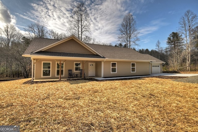 ranch-style house featuring a porch, roof with shingles, and an attached garage