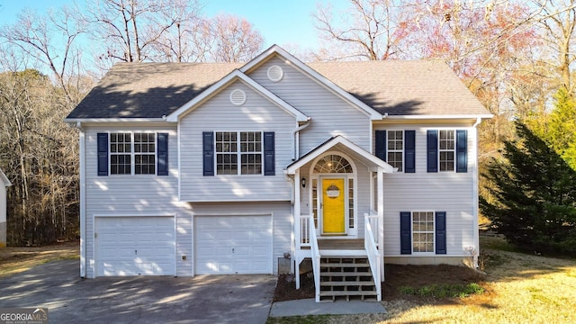 bi-level home with roof with shingles, driveway, and an attached garage