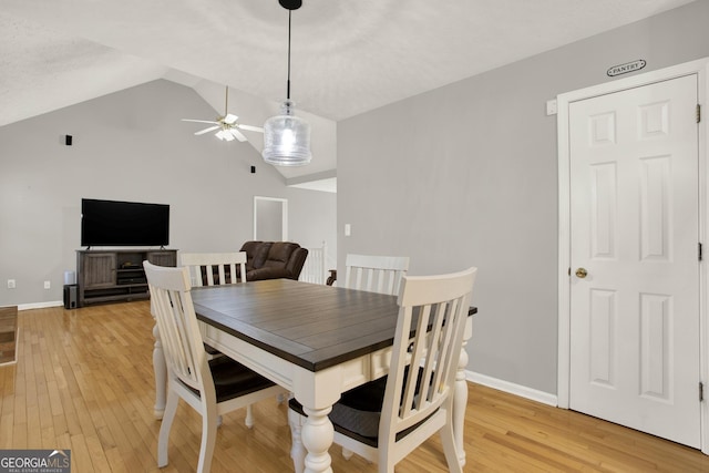 dining area with vaulted ceiling, ceiling fan, light wood finished floors, and baseboards