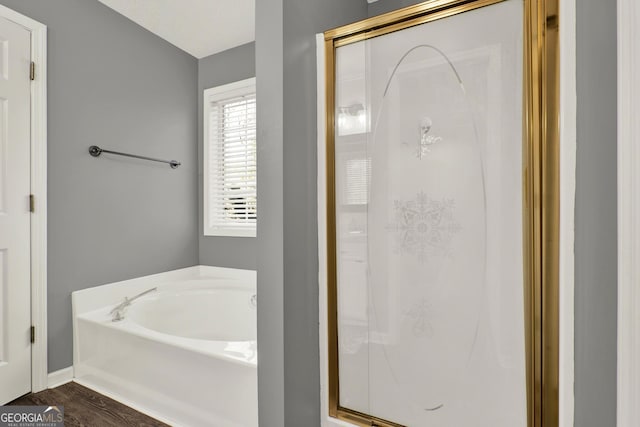 bathroom featuring wood finished floors, a shower stall, and a bath