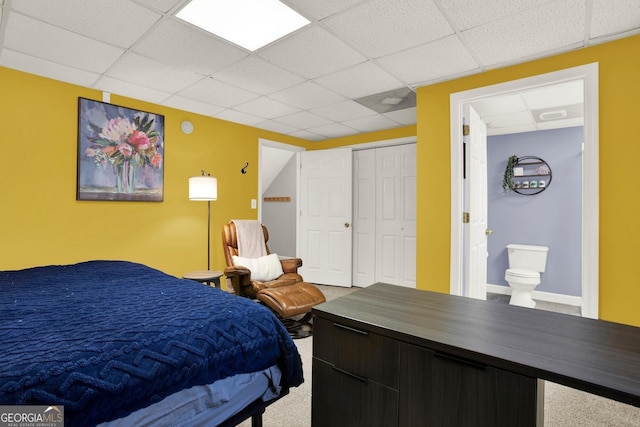 bedroom with a closet, a drop ceiling, and ensuite bathroom