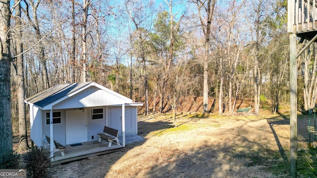 view of yard with an outbuilding and a view of trees