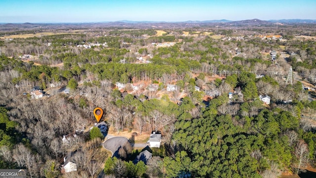 drone / aerial view featuring a mountain view and a wooded view