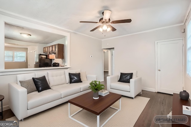 living room featuring crown molding, baseboards, ceiling fan, and wood finished floors