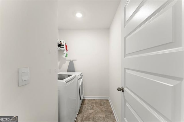 clothes washing area with laundry area, baseboards, and independent washer and dryer