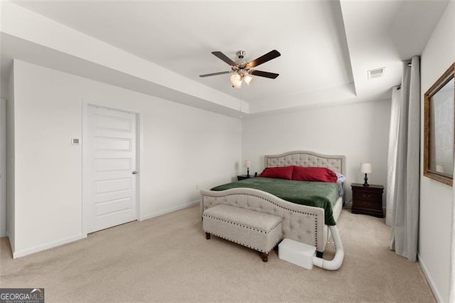 bedroom featuring carpet flooring, a ceiling fan, visible vents, baseboards, and a raised ceiling