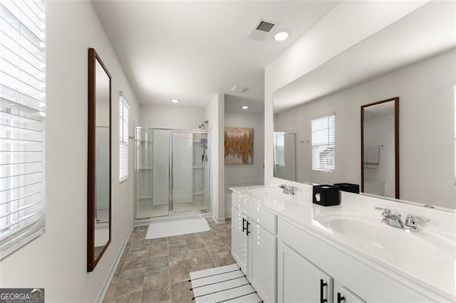 bathroom featuring double vanity, recessed lighting, visible vents, a stall shower, and a sink