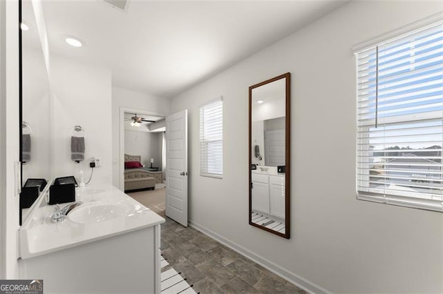 ensuite bathroom with a wealth of natural light, a sink, ensuite bath, and double vanity