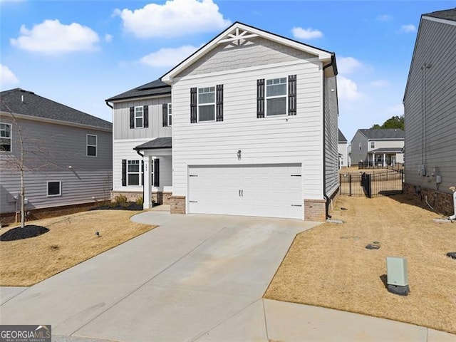 view of front of property with an attached garage, solar panels, fence, driveway, and board and batten siding