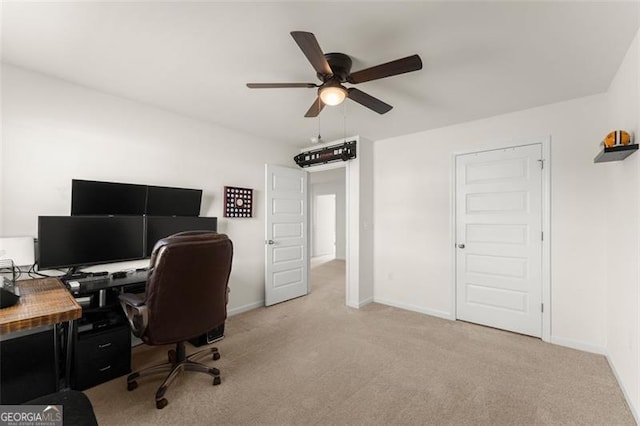 office area featuring a ceiling fan, light carpet, and baseboards