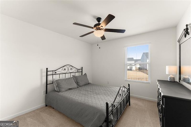 bedroom with light carpet, baseboards, and a ceiling fan