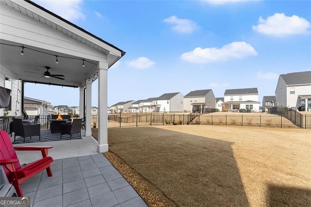 view of yard with a patio area, a fenced backyard, a residential view, and ceiling fan