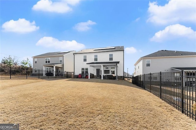 rear view of house featuring a patio, a lawn, and a fenced backyard