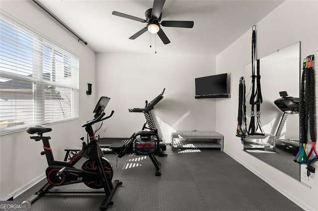 workout room with baseboards and a ceiling fan