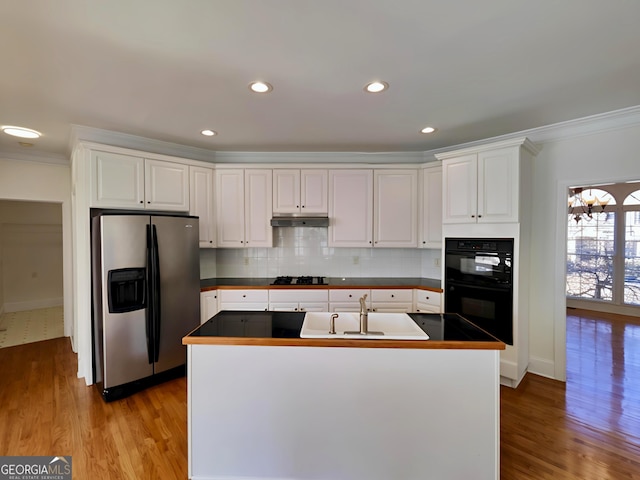 kitchen featuring under cabinet range hood, a sink, white cabinets, black appliances, and dark countertops