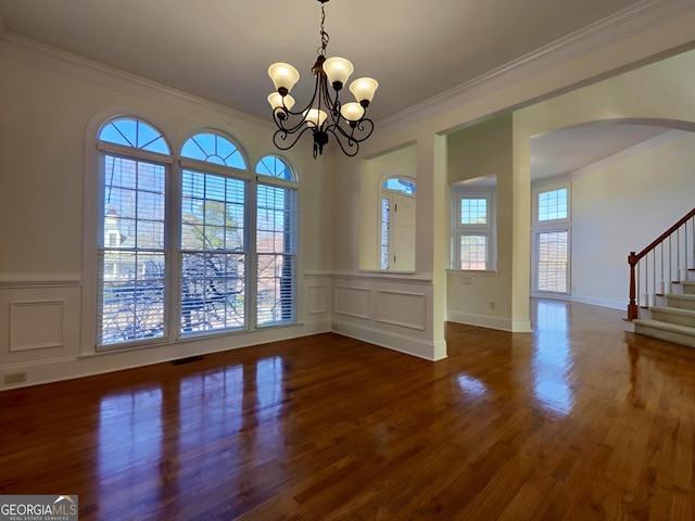 unfurnished dining area featuring stairs, visible vents, crown molding, and wood finished floors