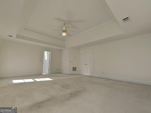 spare room featuring a raised ceiling and visible vents