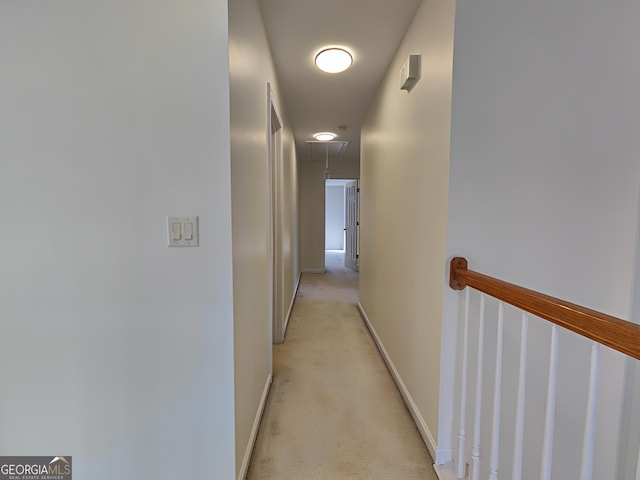 corridor featuring baseboards and light colored carpet