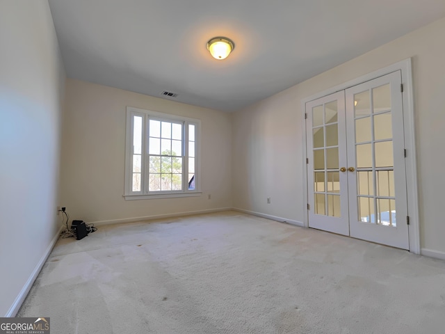 carpeted spare room with french doors, visible vents, and baseboards