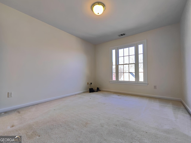 unfurnished room featuring carpet, visible vents, and baseboards