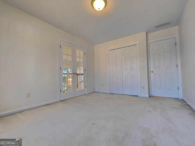 unfurnished bedroom with carpet, french doors, visible vents, and baseboards