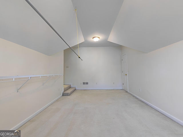 additional living space with carpet floors, visible vents, stairway, and baseboards