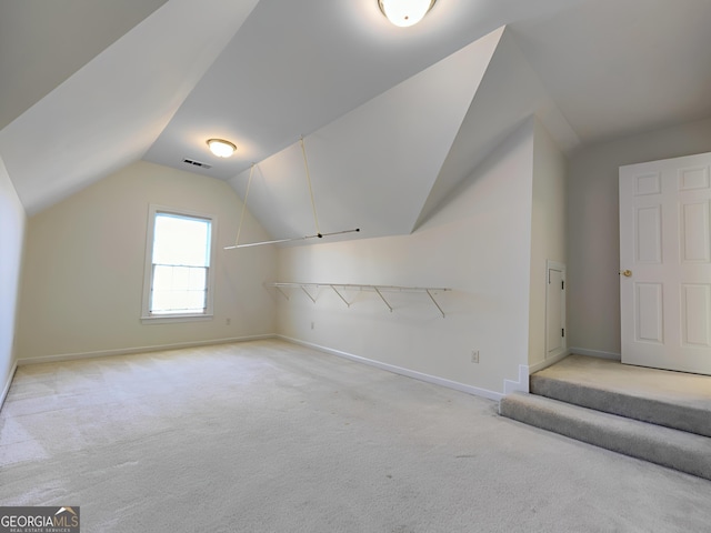 bonus room featuring vaulted ceiling, baseboards, visible vents, and light colored carpet