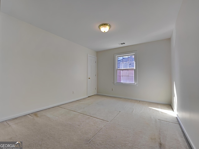 empty room featuring carpet floors, baseboards, and visible vents