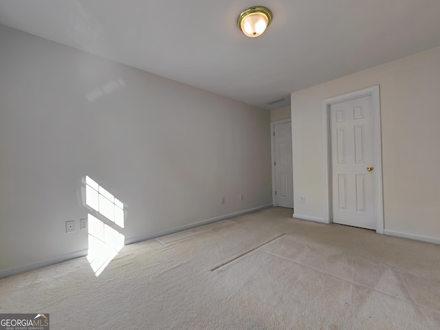 unfurnished bedroom featuring carpet flooring, visible vents, and baseboards