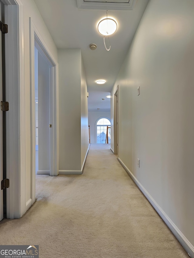 corridor with carpet flooring and baseboards