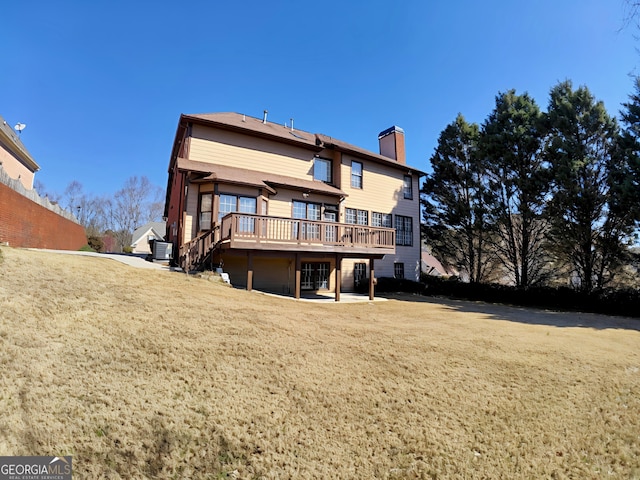 rear view of property with a chimney, a lawn, stairway, a patio area, and a deck