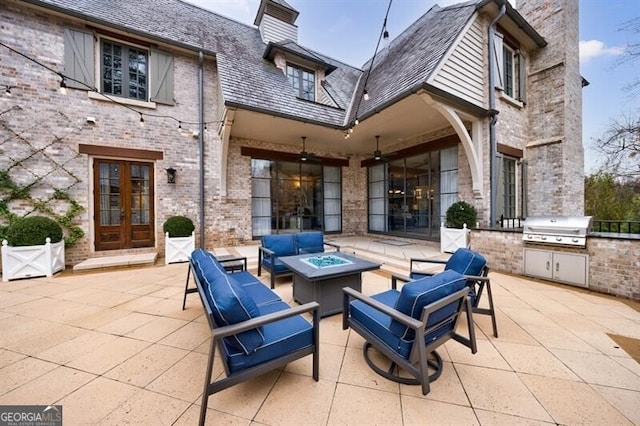 view of patio with an outdoor living space with a fire pit, area for grilling, fence, exterior kitchen, and french doors