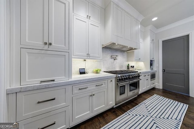 kitchen featuring range with two ovens, dark wood-style flooring, recessed lighting, decorative backsplash, and white cabinets