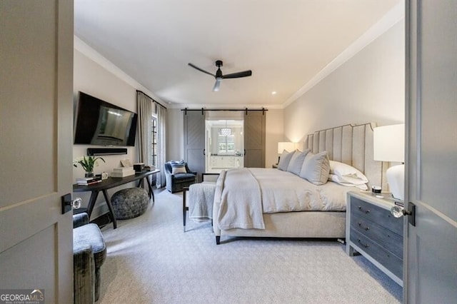 carpeted bedroom with a barn door, ceiling fan, and crown molding