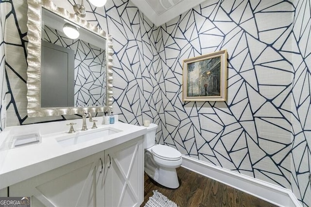 bathroom featuring wood finished floors, vanity, toilet, and wallpapered walls