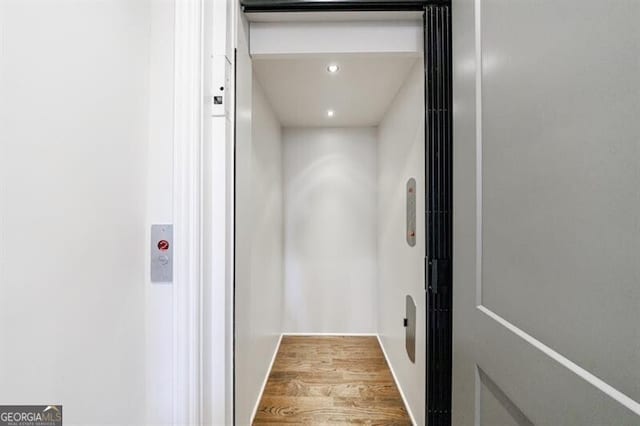 details with elevator, baseboards, wood finished floors, and recessed lighting