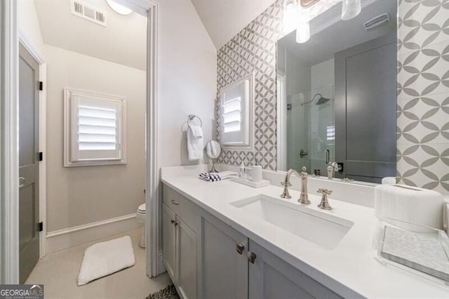 full bath with wallpapered walls, a stall shower, visible vents, toilet, and vanity