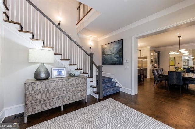 entrance foyer with baseboards, stairs, and crown molding