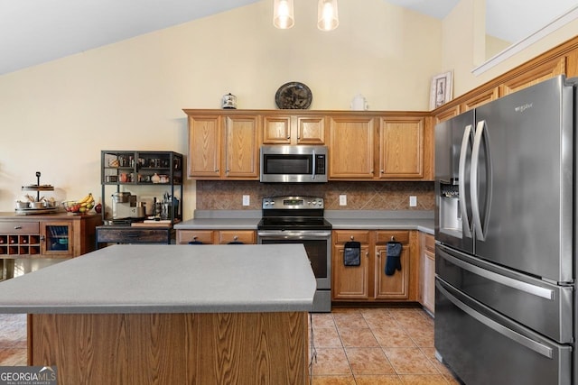 kitchen featuring stainless steel appliances, light tile patterned flooring, brown cabinets, and decorative backsplash