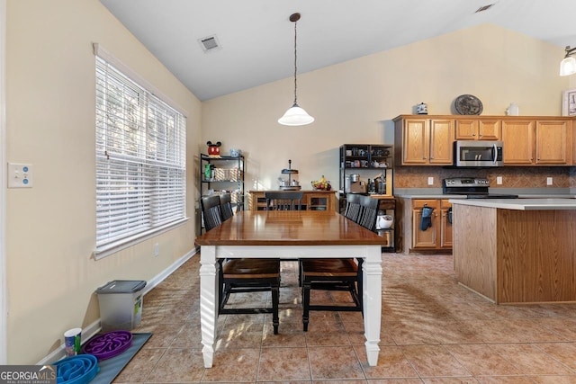 kitchen with light tile patterned floors, stainless steel appliances, visible vents, backsplash, and brown cabinets