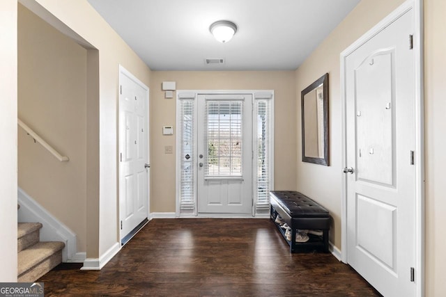 foyer with baseboards, stairs, visible vents, and wood finished floors