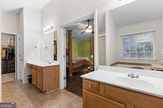 bathroom featuring ceiling fan, two vanities, a sink, and tile patterned flooring