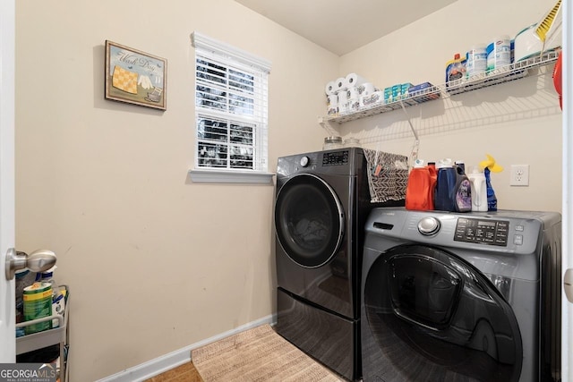 laundry area with laundry area, washer and clothes dryer, and baseboards