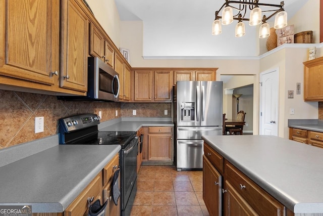 kitchen with light tile patterned floors, stainless steel appliances, hanging light fixtures, brown cabinets, and tasteful backsplash