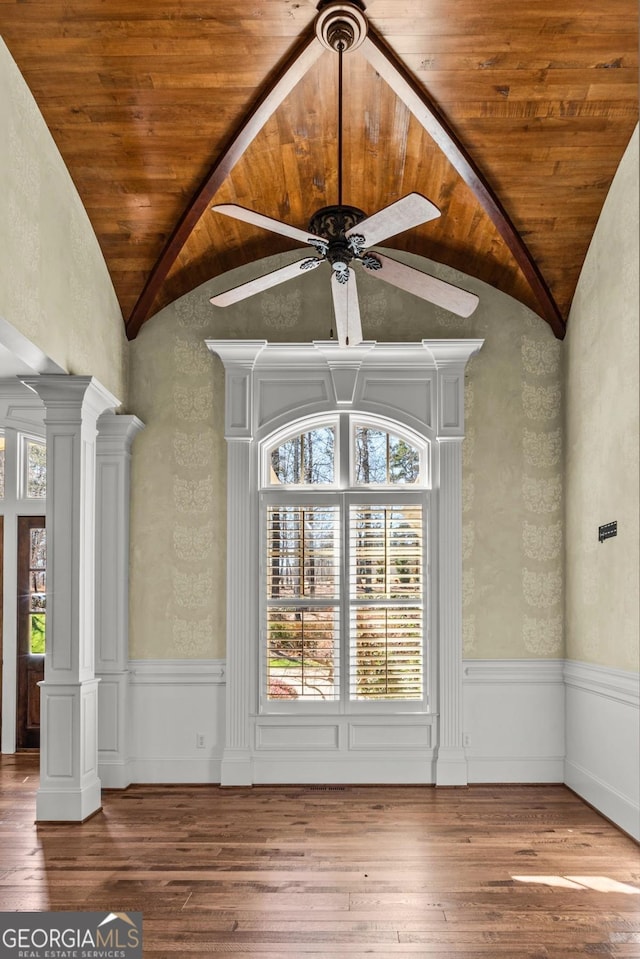 interior space with wooden ceiling, a wainscoted wall, decorative columns, and hardwood / wood-style floors