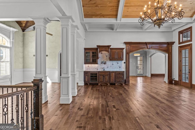 interior space featuring arched walkways, dark wood-style floors, wine cooler, beamed ceiling, and ornate columns