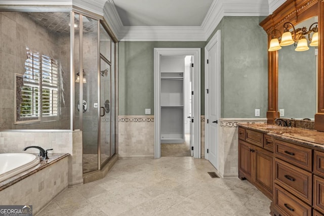 bathroom with vanity, tile walls, a bath, a stall shower, and crown molding