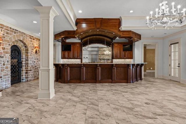 kitchen featuring arched walkways, light stone counters, ornamental molding, decorative backsplash, and ornate columns