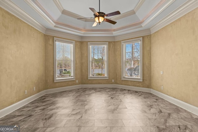 empty room featuring ornamental molding, a tray ceiling, ceiling fan, and baseboards