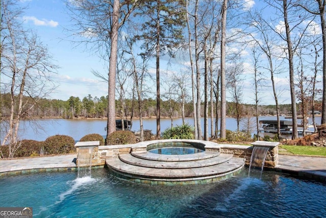 pool with a water view and an in ground hot tub